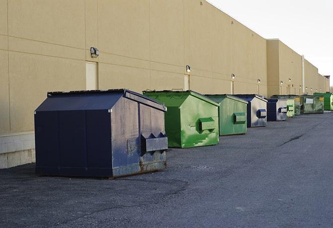 a group of dumpsters lined up along the street ready for use in a large-scale construction project in East Marion NY